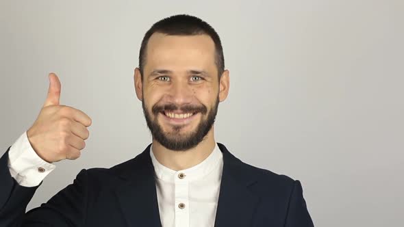 Young Handsome Businessman Is Smiling and Showing Thumb Up with Two Hands.