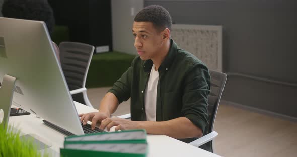 Multinational People Sit at Desks Working on Computers