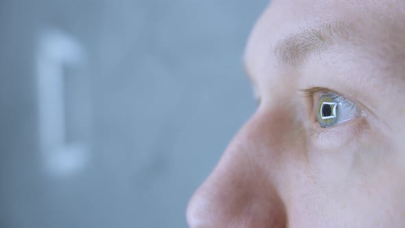 Illuminated Square Mirror Reflected in Wide Open Eyes of Grayeyed Man Closeup alt