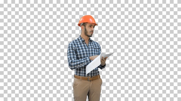 Young engineer in helmet checking construction plan, Alpha Channel