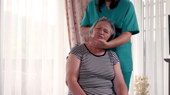 Female Nurse Giving Head Massage to Senior Woman at Home