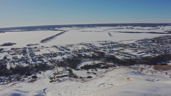 The Village Appears From Behind the Snowy Mountains on a Bright Sunny Day