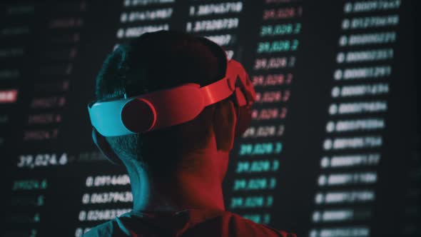 Trader in a Virtual Reality Helmet Looks at Cryptocurrency Charts alt