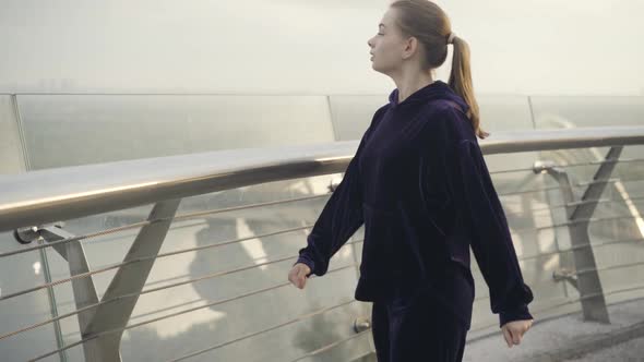 Slim Confident Sportswoman Running To Bridge Handrail Stopping and Signing alt