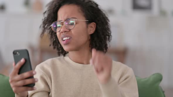 Portrait of African Woman Loss on Smartphone alt