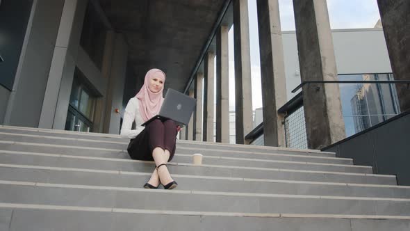 Portrait of Attractive Arabian Woman in Elegant Clothes and Hijab Sitting on alt