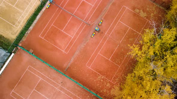 Aerial tennis courts in city park, yellow autumn