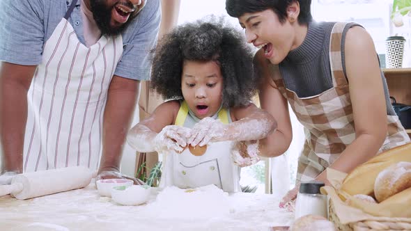 Close up of Happy African American girl thresh dough with dad and mom together