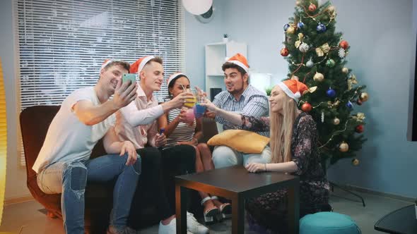 Cheerful Friends in Santa Hats Making Video Call By Smartphone on Christmas Party alt