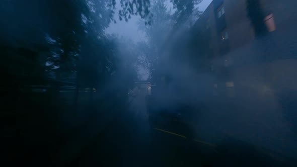 Fpv Drone Flies Along the Early Morning Foggy and Rainy Street