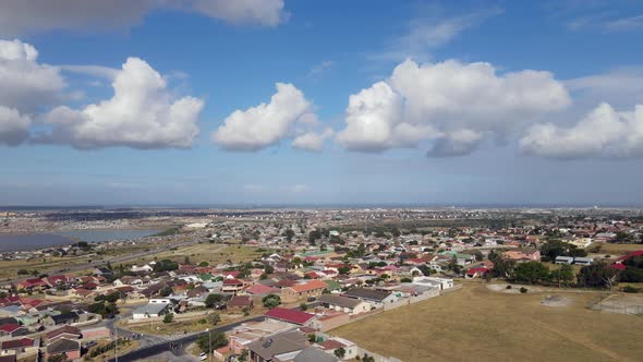 Aerial View of Drone Flying Over Residential Area with Clouds Hovering Above