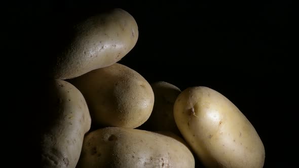 Vegetables Potatoes Gyrating on Black Background. Solanum Tuberosum alt