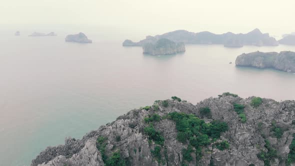 Aerial: flying over Cat Ba and Ha Long Bay rock pinnacles at sunset, travel destination Vietnam alt