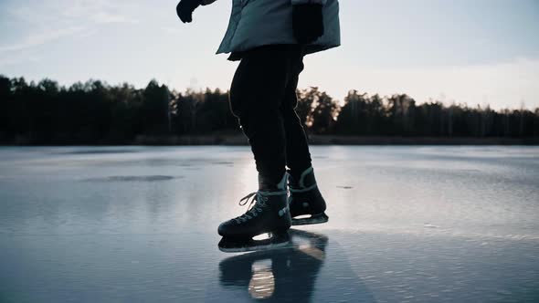 Man Practice Ice Skating on a Clear Frozen Lake on Sunny Day in Nature