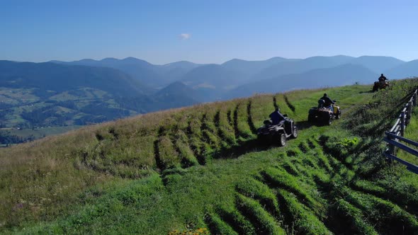 Men Riding Quad Bikes on Mountains Background alt
