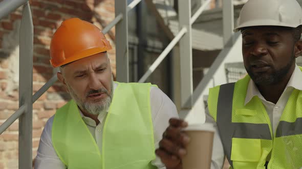 Workmen Taking Break and Drinking Coffee Outdoors alt