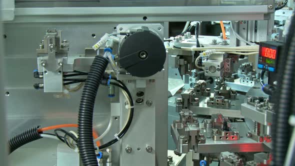 Advanced industrial production line for small parts, robotic arms working alt