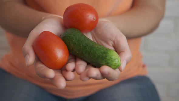 Cucumber with Tomatoes in Female Hands alt