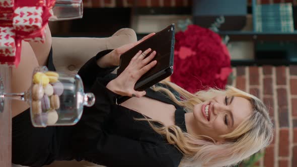 Vertical Video Elegant Blonde Woman Smiling at Tablet Computer While Talking with Remote Boyfriend alt
