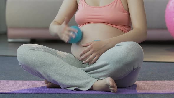 Expecting Woman Rolling Massage Balls Over Stomach, Relaxing Therapy, Body Care alt