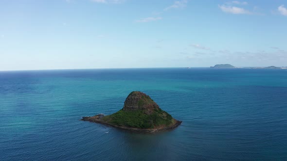 Aerial reverse pullback shot of Mokoli'i island, also known as Chinaman's Hat, on the island of O'ah alt