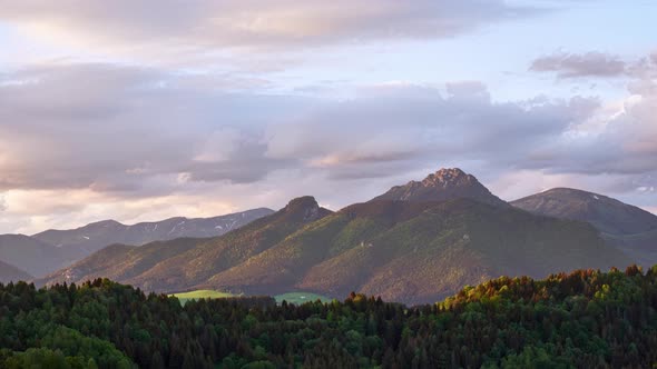 Time Lapse Motion of Fast Clouds Over Misty Alps Mountain Peak in Sunny Spring Nature at Sunset