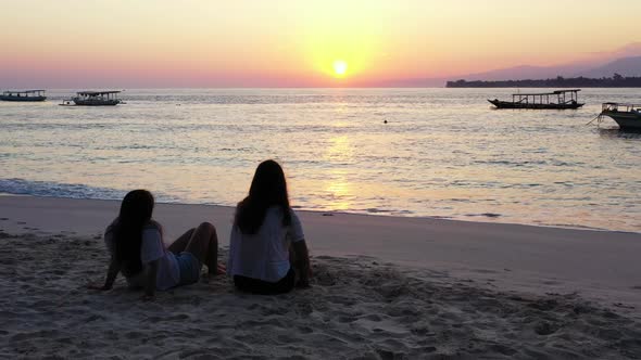 Girls tan on perfect coast beach vacation by blue ocean and white sand background of Gili Air near r alt