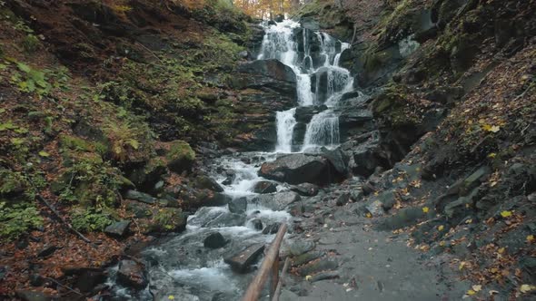 Pictorial Foaming Waterfall Near Grey Ground Path in Autumn
