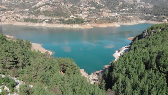Aerial view of the beautiful mountain lake with turquoise clear water with green pine trees forest alt