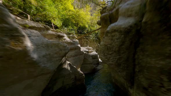 Aerial Close View Flight Between Sunny Cliff Formation with Forest Green Tropical Tree alt