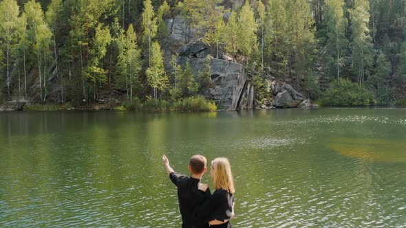People are standing on the shore of a crystal lake Bazhov places Turquoise water in the lake alt