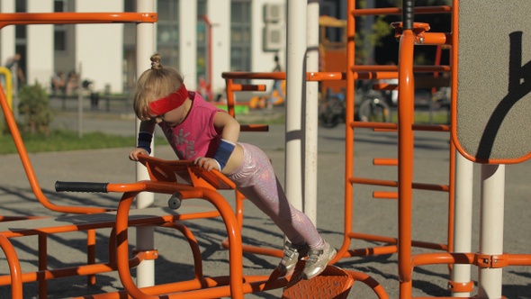 Young Girl in Sportswear Making Push-ups Exercises on Playground. Workout for Kids. Athletic Child alt