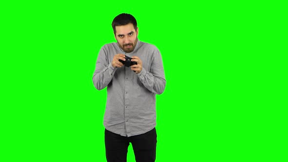 Brunette Guy Is Playing a Video Game Using a Wireless Controller and Loses. Green Screen alt