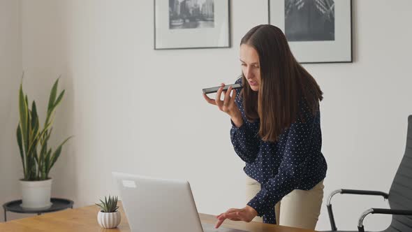Multitasking Young Businesswoman Using Voice Recognition Function on a Smartphone alt