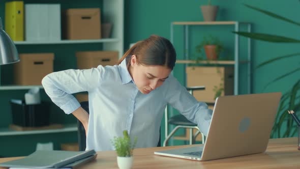 Woman Trying to Get Up From the Table Suddenly Feeling Pain in Back alt