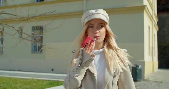 Woman Using a Smartphone Voice Recording Function Online in the City Street, Talking To Mobile alt