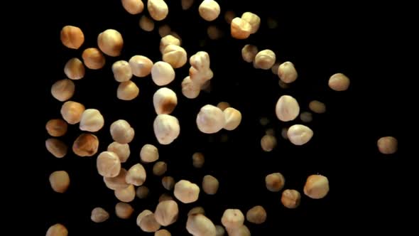 Hazelnuts Are Flying on a Black Background alt