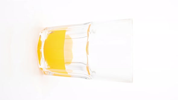 Stop motion animation Healthy orange juice in a glass on white background, Vertical video format.