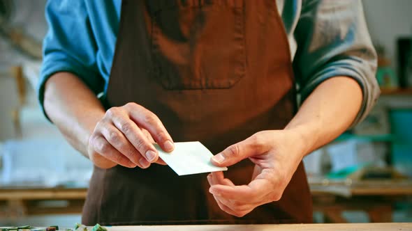 Male hands demonstrating a piece of blue glass alt