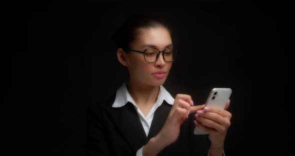 Business Woman Finds an Advantageous Offer in a Cell Phone Pleasantly Surprised