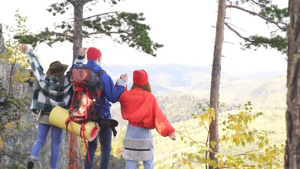 View From Back on Three Friends Tourists Enjoyng Mountains alt