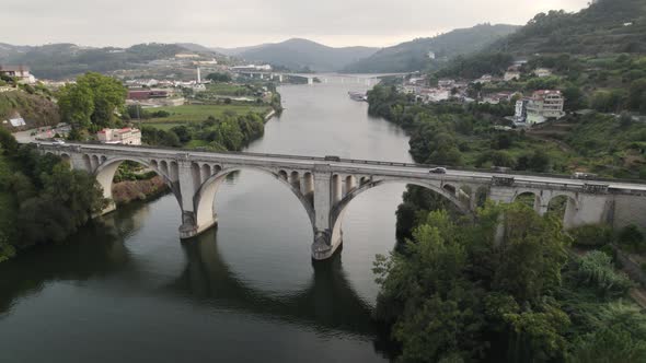 Ponte De Pedra Bridge over Douro river at Entre os Rios town in Portugal. Aerial circling