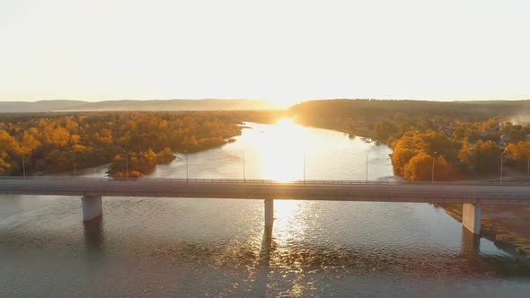 Aerial View of Autumn Forest and River with Empty Bridge Across. Morning Sunrise