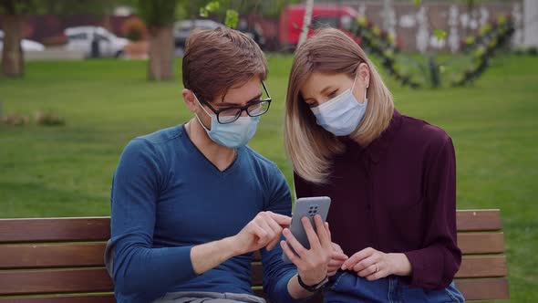 Two cute people look closely on phone and find out from news End of covid-19 alt