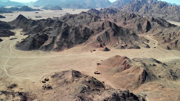 Top view of the Sahara desert, desert mountains. Wooden Bedouin houses. Sands. alt