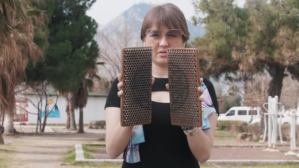 A Woman Holding the Sadhu Board and Showing the Nails to the Camera alt