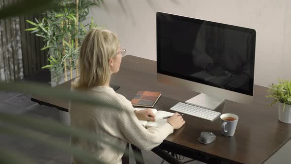 Woman Working and Looking at Computer Listening Lesson and Conference at Home alt