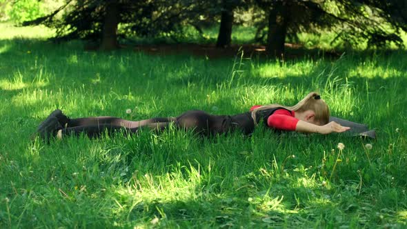 Woman Lying On Stomach And Lifting Body Up Outdoor