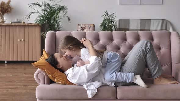 Happy Family Young Mom Playing with Kid Girl on Sofa at Home Mother Tickle Child alt