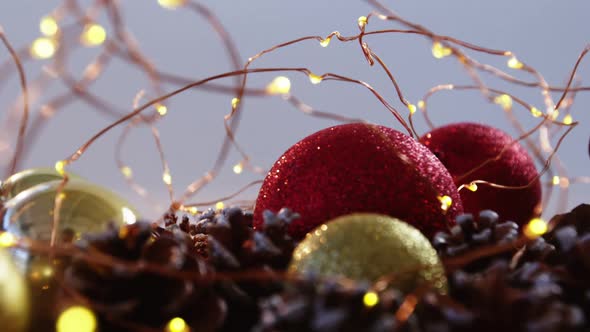 Christmas bauble and pine cone arranged with christmas lights alt